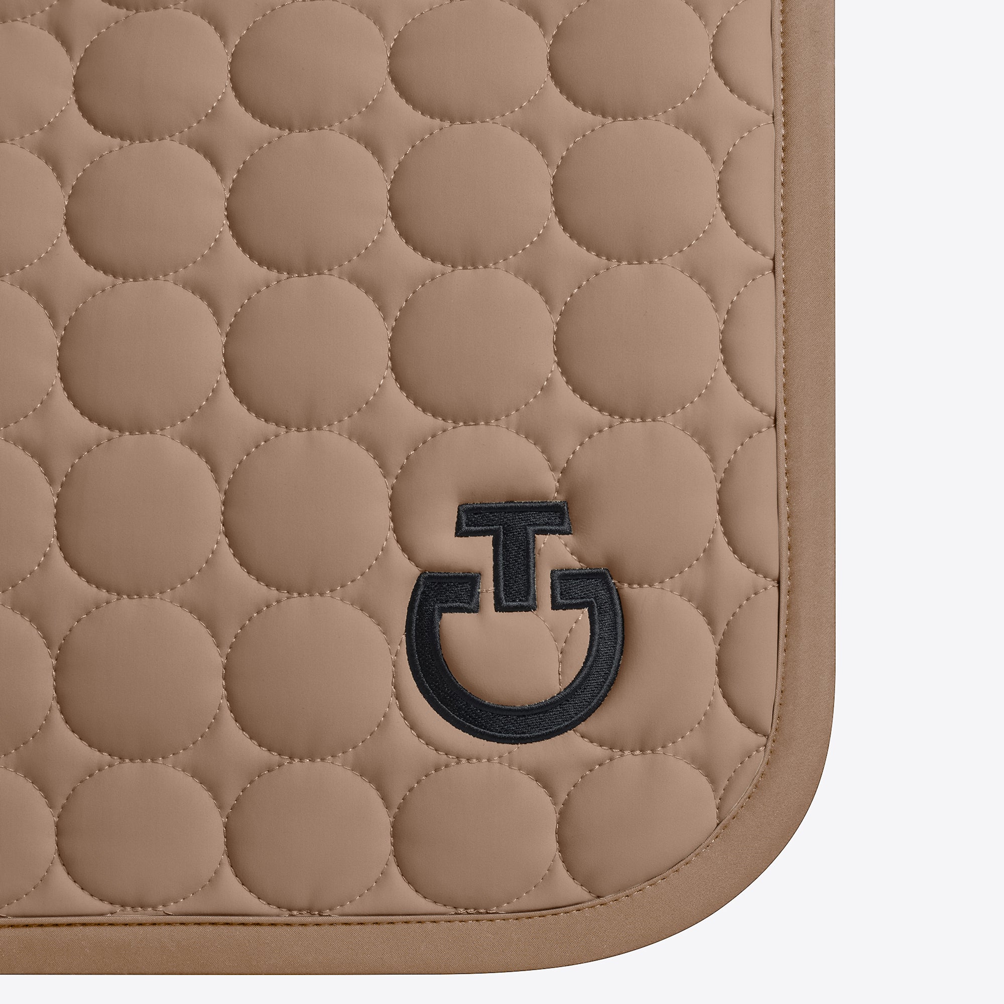 Beige quilted mat with a black logo on a white background