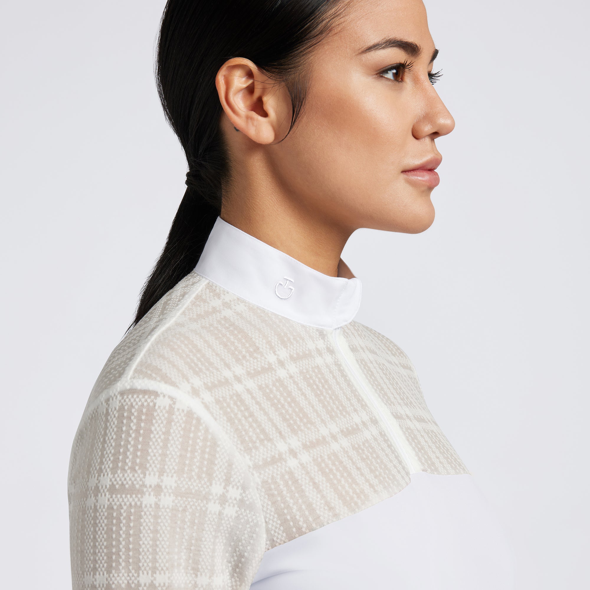 Showcase the Cavalleria Toscana Sheer Jacquard Jersey Zip Competition Shirt with images that emphasize its lightweight and breathable fabric. Highlight the sheer jacquard jersey material, zip closure, and tailored fit through a mix of close-up shots and action shots in an equestrian setting. Focus on the shirt&