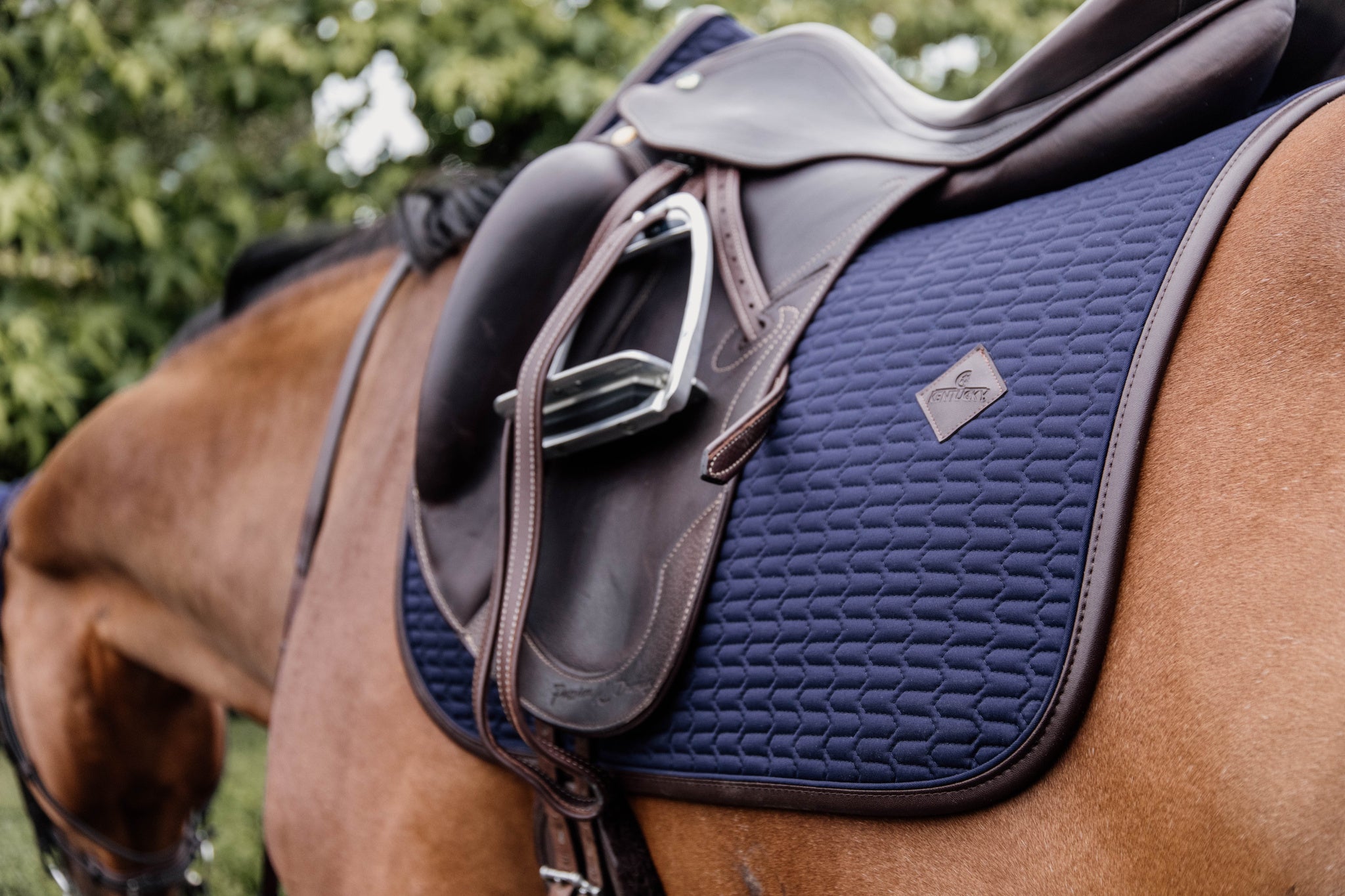 This classy Kentucky dressage pad is designed with beautiful wave quilting and finished with a brown vegan leather trim and logo.
