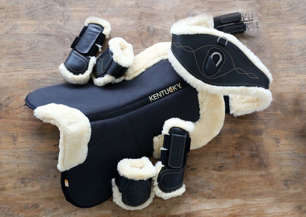 The Kentucky anatomical girth with sheepskin lining. This girth is made from artificial leather, making it softer, more durable and easier to maintain and clean. The faux sheepskin is removable, making it easier to watch and re attaches with strong Velcro. A silver hope and carabiner is found underneath to attach your martingale, breastplate, draw reigns etc. The girth is available in black or brown.