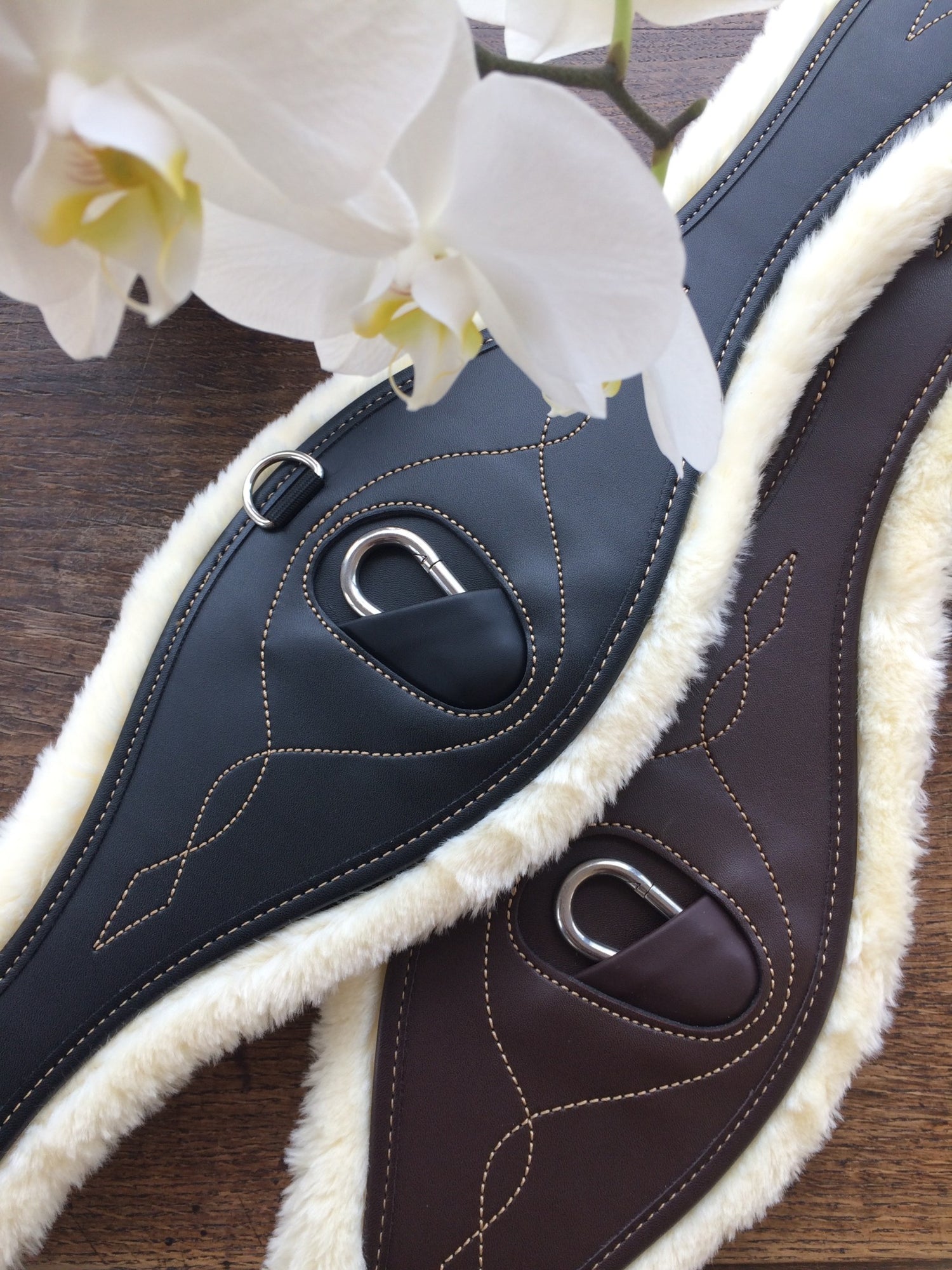 The Kentucky anatomical girth with sheepskin lining. This girth is made from artificial leather, making it softer, more durable and easier to maintain and clean. The faux sheepskin is removable, making it easier to watch and re attaches with strong Velcro.   A silver hope and carabiner is found underneath to attach your martingale, breastplate, draw reigns etc.    The girth is available in black or brown.