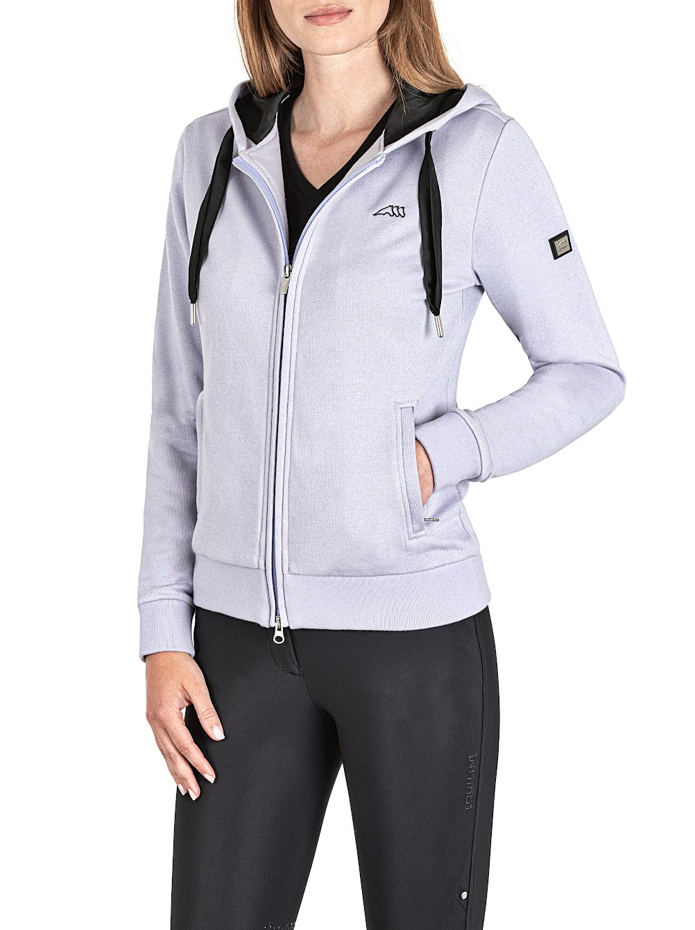 The Equiline Goreg Lilac sparkle hoody adds a subtle touch of glamour. The Hoody has a fine silver sparkle running through the fabric to give the subtle shimmer. Zip front with side insert pockets, a black tie on the hood with the Equiline logo on the sleeve finishes the look. Made from cotton bi stretch jersey and machine washable.