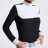 A woman wearing a black and white long-sleeve riding shirt with a half-zip collar. The brand name &