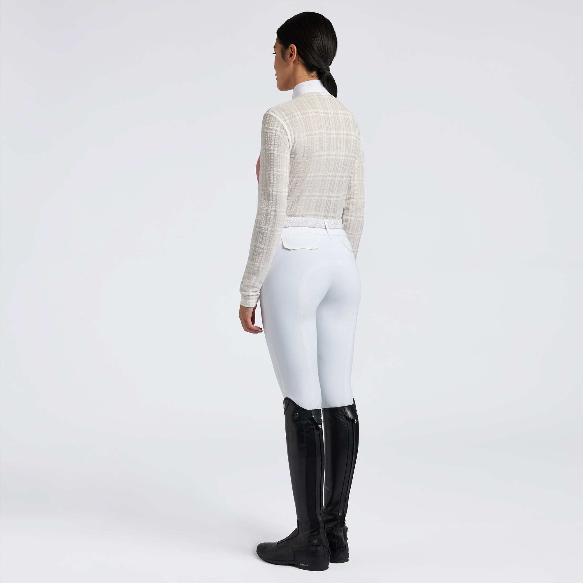 Showcase the Cavalleria Toscana Sheer Jacquard Jersey Zip Competition Shirt with images that emphasize its lightweight and breathable fabric. Highlight the sheer jacquard jersey material, zip closure, and tailored fit through a mix of close-up shots and action shots in an equestrian setting. Focus on the shirt&