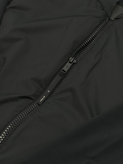 Close-up of a black jacket zipper with a brand logo.