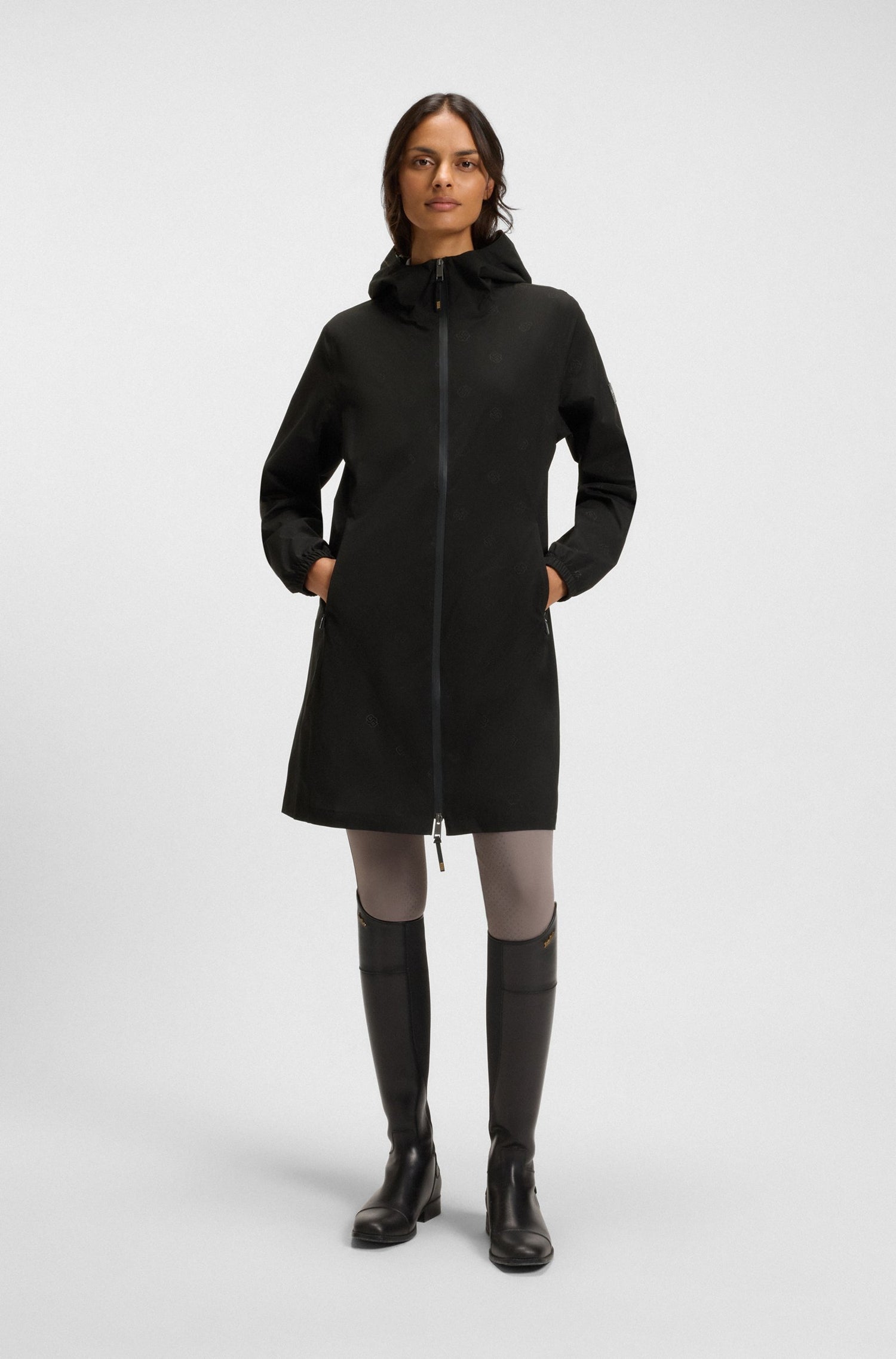 Woman wearing a black coat and black boots on a white background