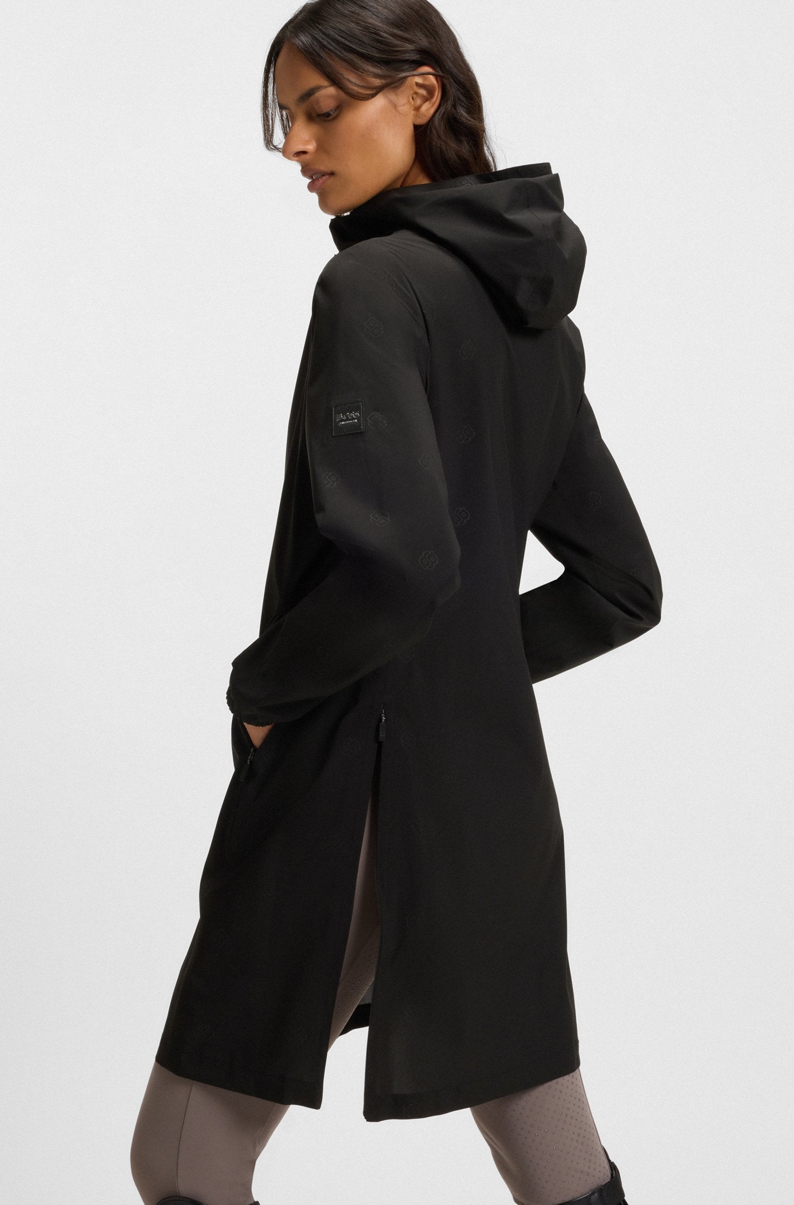 Woman wearing a black hooded coat on a white background