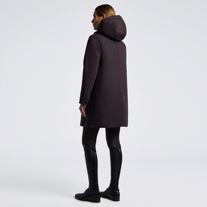 A woman shown from the back wearing a dark plum hooded coat, black leggings, and black boots against a clean light gray studio background.