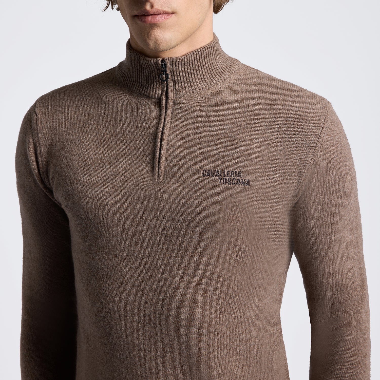A man wearing a brown ribbed knit quarter-zip sweater with &