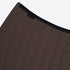 Close-up of a dark brown quilted mat with a circular stitched pattern and a black elastic trim, shown on a light gray background.