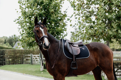 The Kentucky Softshell Jumping Saddle Cloth combines elegance and simplicity with a quilted star pattern and contrast edging.