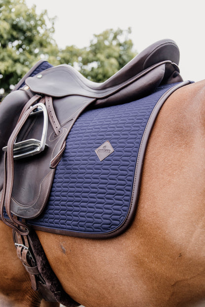 The Kentucky Saddle Pad colour Edition leather is a modern twist with the wave pattern on a classic pad.  The Kentucky pad is a very stylish and fashionable with an artificial leather binding (vegan friendly) and The Kentucky logo. The logo is always placed in a central, slightly higher place which leaves room for embroidery of your own logo if desired. 
