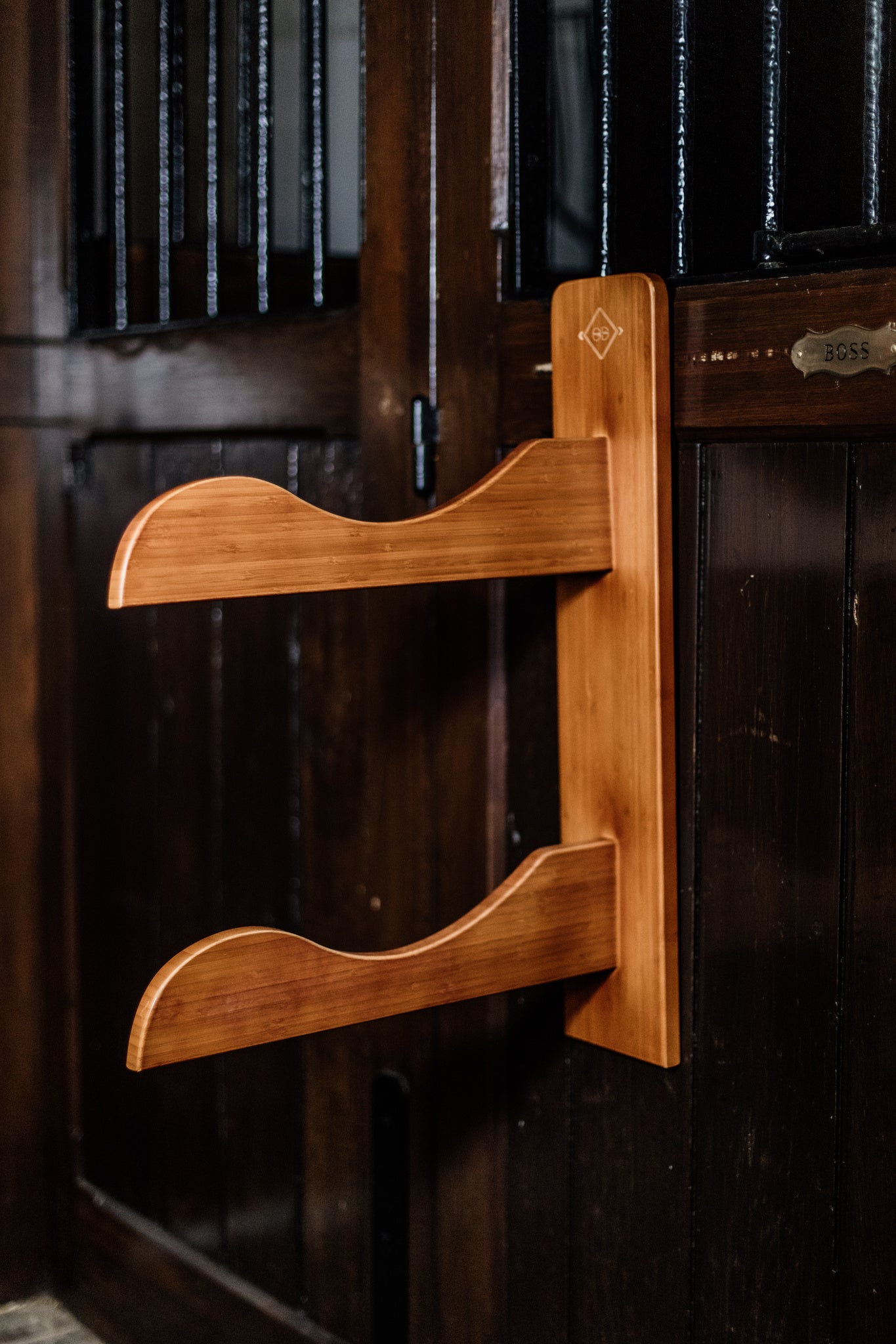 Kentucky saddle rack with two saddle pegs. Made with strong bamboo and finished with a small gold Kentucky logo. This is the perfect piece for any tack room.
