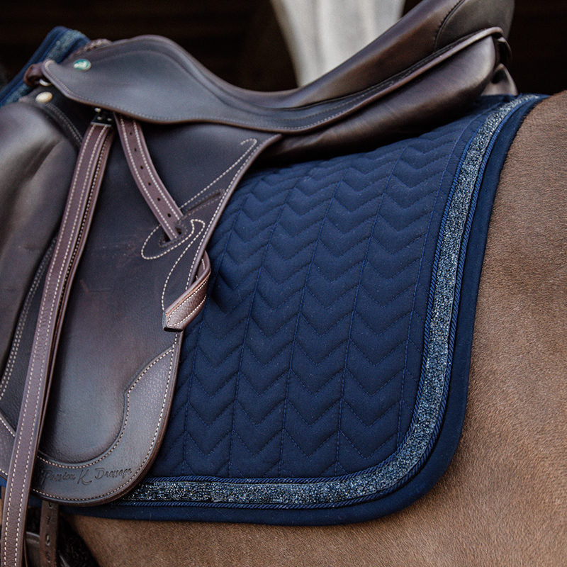 Let your horse shimmer with the Kentucky dressage Glitter and Stone Pad. The pad is of the usually high quality you know from Kentucky with excellent cushioning between the horse’s back and the saddle and therefore protecting the horse against friction.    matching fly vale available in standard and soundless options.   Machine washable at 30’c in a wash bag. 
